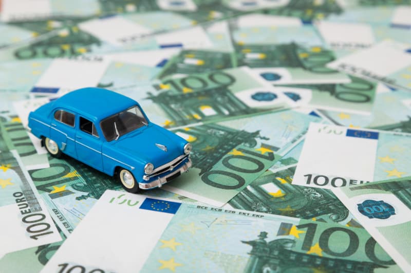 Coche de juguete sobre billetes de 100 euros